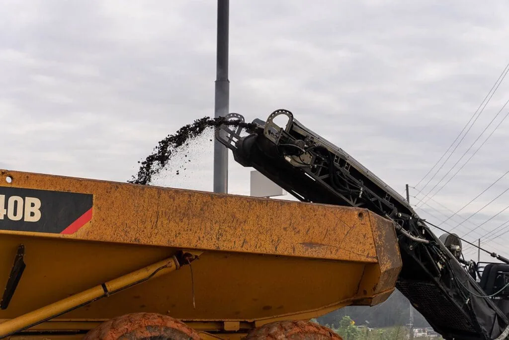 cold planer loading asphalt millings into a dump truck